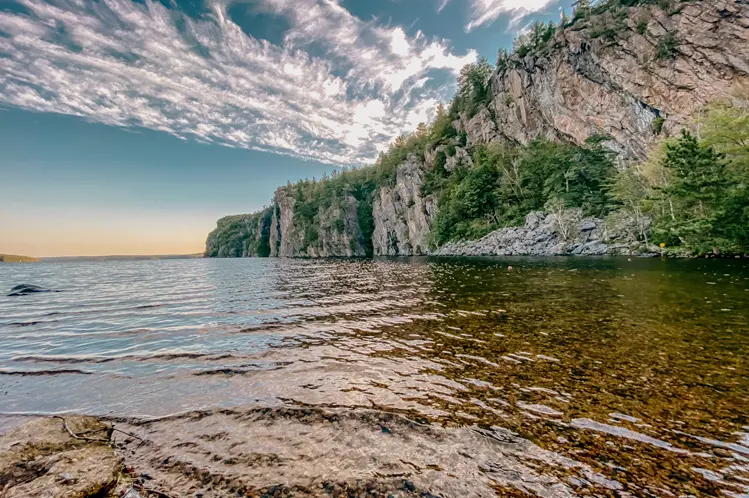 La imponente roca Mazinaw reflejándose en el lago en un día soleado en el Parque Provincial Bon Echo.