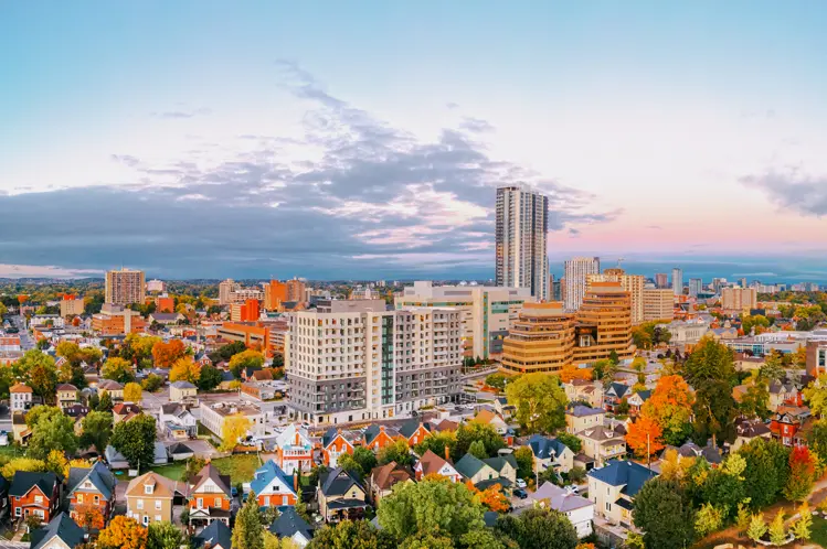 Paysage urbain de Kitchener au coucher du soleil sous un ciel dramatique strié de nuages.