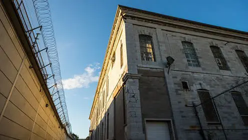 Die Sonne scheint auf ein Gebäude innerhalb der Gefängnismauern