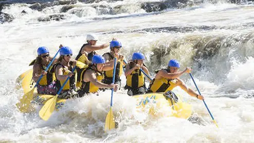 Groupe dans un canot pneumatique sur des rapides d'eau vive