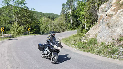 굽은 길을 달리는 오토바이를 탄 사람