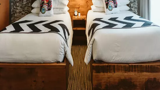 Plush bedding and soft lighting highlight the accent wall in a boutique hotel room