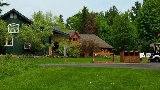 Césped verde bien cuidado y bosque rodean el campo de golf principal