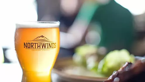 Full glass of beer with Northwinds engraved on it