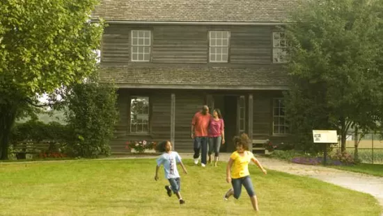 Two adults and two children playing in front of a historic building