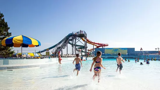 Children in swimming clothes are having fun in the pool as lifeguards watch the kids