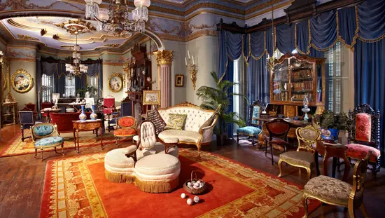 Salles de dessin d'un manoir historique avec meubles, draperies et chandeliers d'époque.