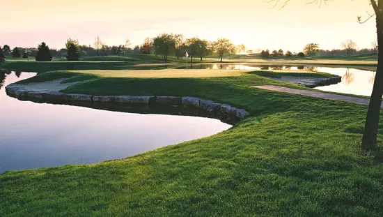 Étangs d'eau stagnante serpentant parmi des chenaux d'herbe entrecoupés de zones de petites pierres.