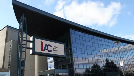 左下にガラスの入り口があるガラス板だけで作られた正面と側壁を示す高層ビル