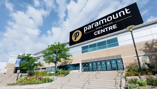 Breite Außentreppe zwischen Gärten, die zu einem langen Gebäude mit 9 Glaseingangstüren unter einer Reihe großer Fenster führt