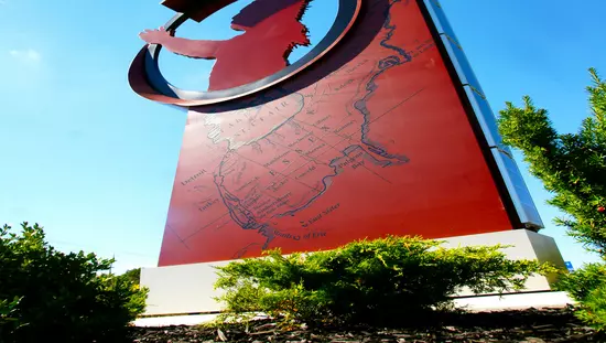 Enormous red sign showing township map and with circle cut out at top around sculpted outline of native chief with headdress