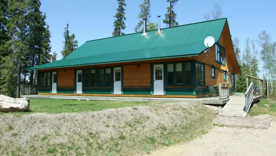A wooden  building at the top of a small hill