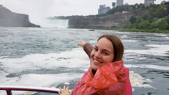 ナイアガラの滝の風景を指すボートに乗った少女