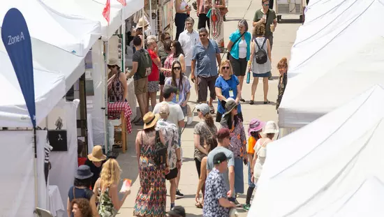 テントブースを閲覧したり歩き回ったりする人々