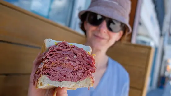 Woman displaying her meat sandwich to the camera