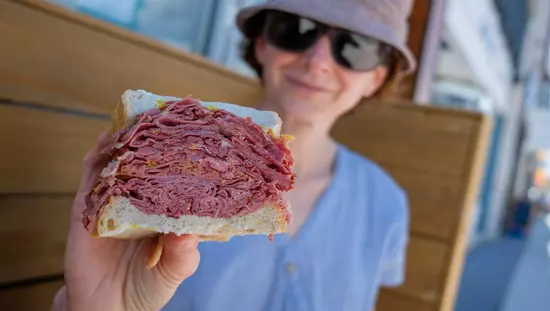 Woman displaying her meat sandwich to the camera
