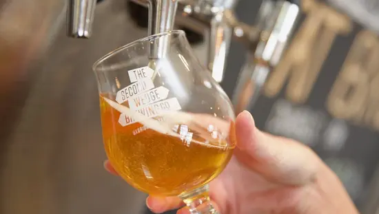 A glass of beer being poured from a beer tap