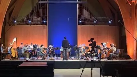 Eine wunderschöne Holzgewölbedecke befindet sich über einer Symphonie, die auf der Bühne spielt
