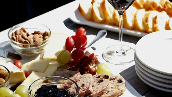 Une charcuterie, un verre à vin et des assiettes