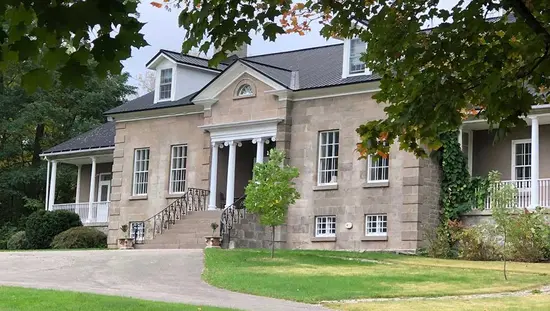  Une grande maison en pierre nichée entre les arbres