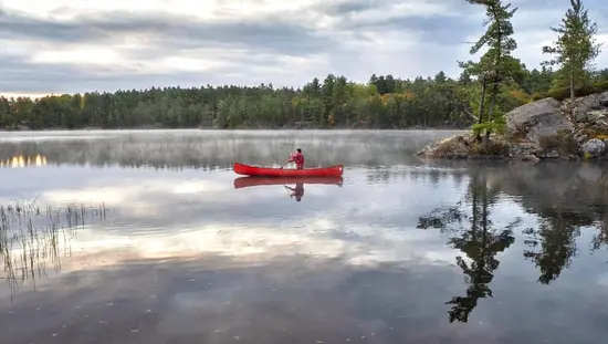 Un hombre remando en una canoa en el lago.