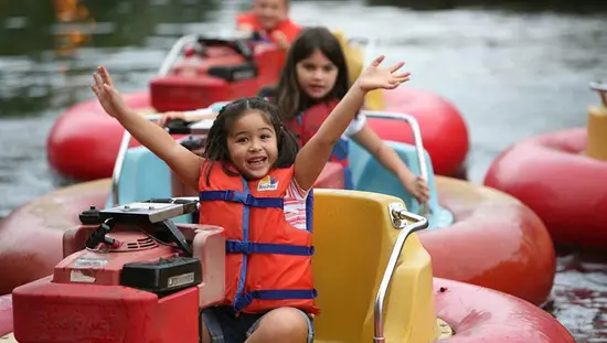 Enfants qui s’amusent en se promenant dans de petits bateaux sur l’eau.