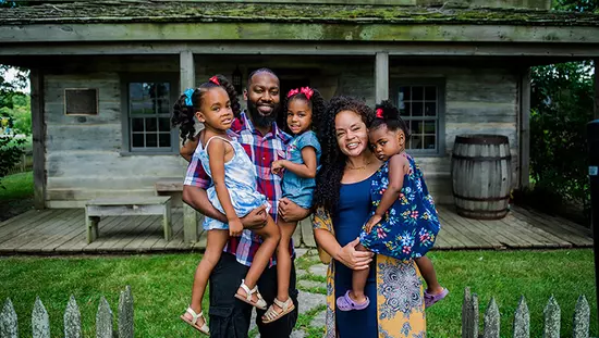 Una familia de cinco frente a una casa histórica