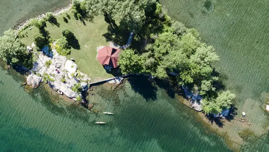 Vista aérea de una costa rocosa, aguas limpias y dos kayakistas en el área de las Mil Islas del río San Lorenzo.