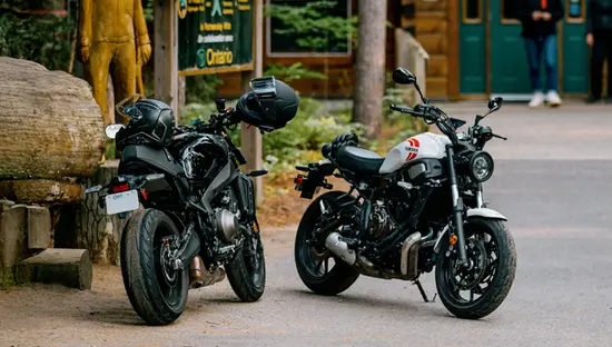 Zwei Motorräder parken vor dem Besucherzentrum im Algonquin Provincial Park, mit einer Holzstatue, Waldschildern und zwei Personen in der Nähe des Eingangs.