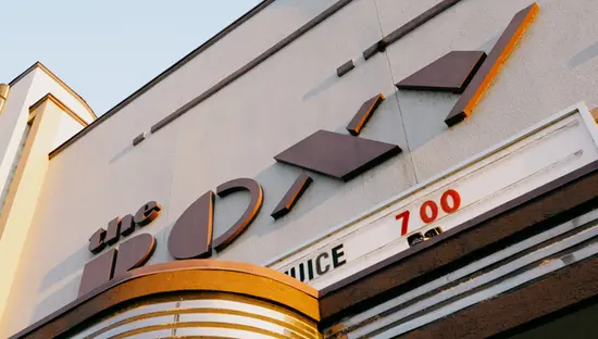  Pastellfarbene Außenseite des Roxy Theatre in Uxbridge mit einem Retro-Stil-Display, auf dem aktuelle Filmtitel angezeigt werden.