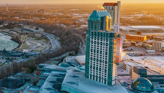Vista aérea de las Cataratas Horseshoe y el centro de las Cataratas del Niágara al atardecer, con la niebla elevándose y los tejados cubiertos de nieve.