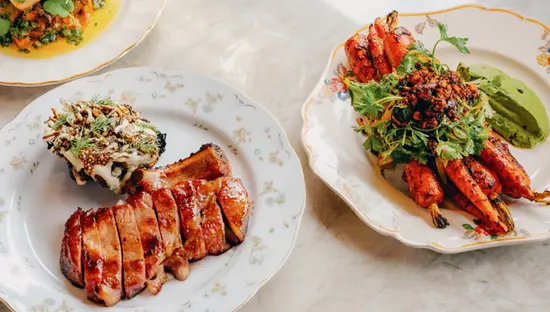 Gebratener Fisch, glasiertes Schweinekotelett, geröstete Karotten und Wein werden im The Wood Owl in Toronto serviert, einem im Guide Michelin aufgeführten Restaurant.