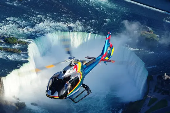 A helicopter by Niagara Helicopters flying above Niagara Falls.