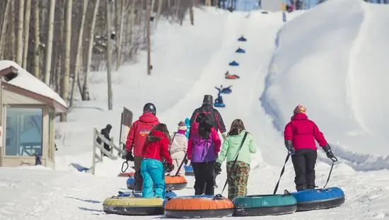 A family pulls inner tubes towards a snow tubing hill at Mount Jamieson in Timmins.