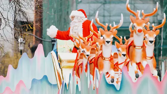 Papá Noel saluda desde una colorida carroza formada por su trineo y sus renos.