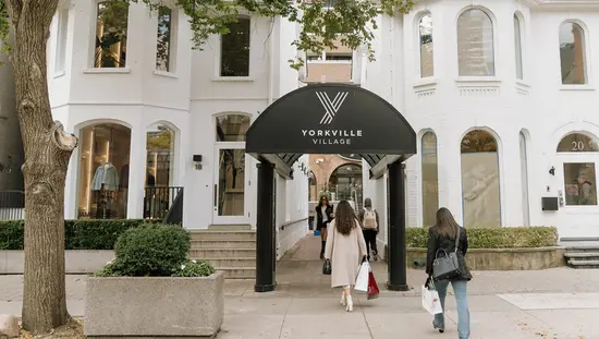 トロントのヨークビルにあるビクトリア朝の建物内のブティック ショッピング センターに買い物客が出入りしている。