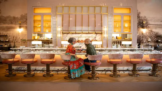 A couple sits on plush barstools at Zoe’s, the stylish, warm and romantic lounge at Ottawa’s iconic Fairmont Château Laurier. 