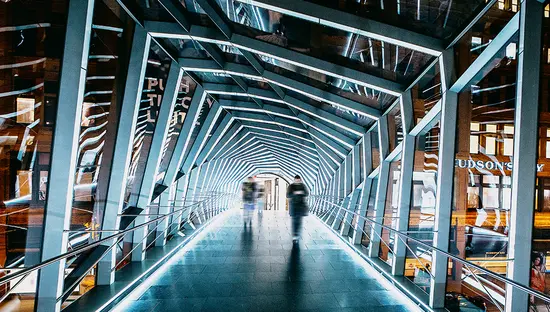 Una pasarela iluminada futurista con paredes de cristal y un diseño geométrico en Toronto, que brilla con luz blanca.