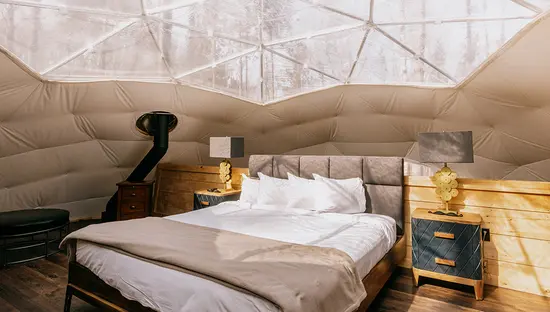 Ein bequemes Bett in einer Glamping-Kuppel auf der Glen Oro Farm.