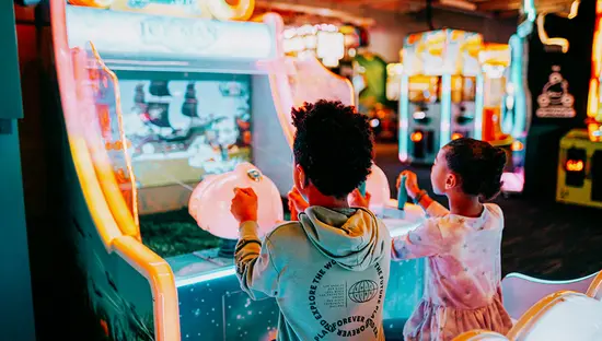 Two young children enjoy playing an arcade game at The Factory in London, Ontario.