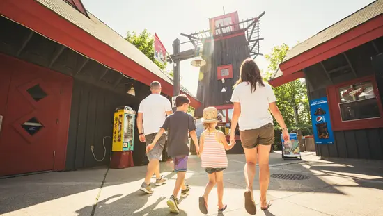 A family walking in the Adventure Village Amusement Park.