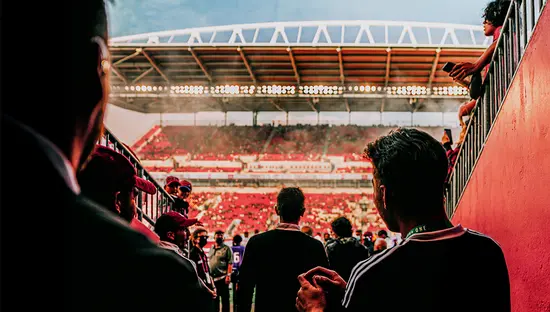 Joueurs de soccer traversant le tunnel d’un stade en direction du terrain avant un match.