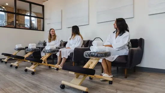 Tres mujeres se relajan y charlan en el spa y centro social de la refinería.