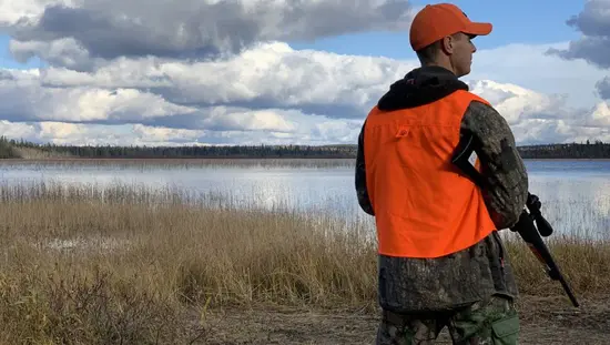 A man holding a firearm on a grouse hunting trip in Algoma Country in Northern Ontario.