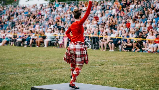 Bailarina de las Tierras Altas actuando ante una gran multitud en el Festival Escocés de Fergus.