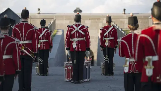 Un groupe d’acteurs en costume d’époque présente une reconstitution militaire avec démonstration musicale au lieu historique national du Fort-Henry à Kingston.
