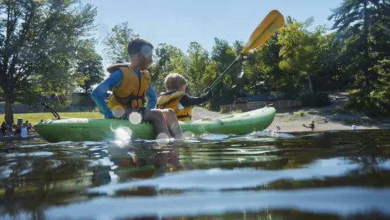 Deux jeunes garçons faisant du kayak et jouant dans un lac par une belle journée d’été.