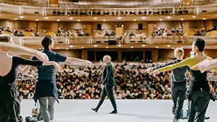 Vue sur des danseurs de ballet se produisant devant un large public depuis la scène.