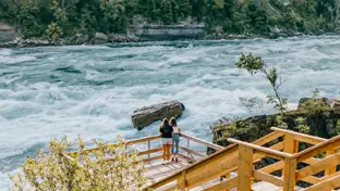 Deux personnes sur le sentier White Water Walk contemplant les rapides déchaînés.