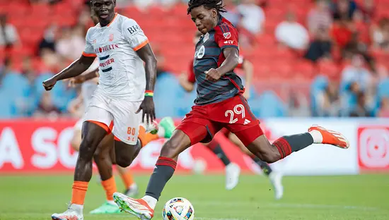 Players on a soccer field in a soccer stadium